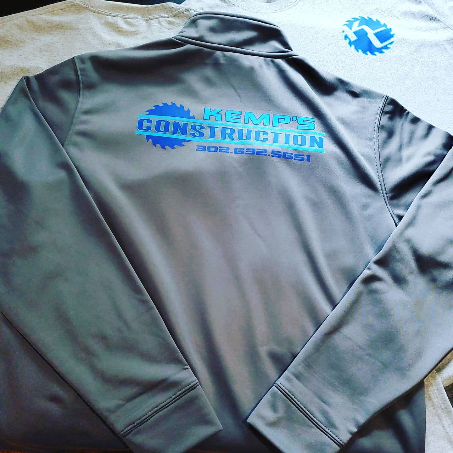 Gray quarter-zip pullover printed with the Kemp's Construction logo